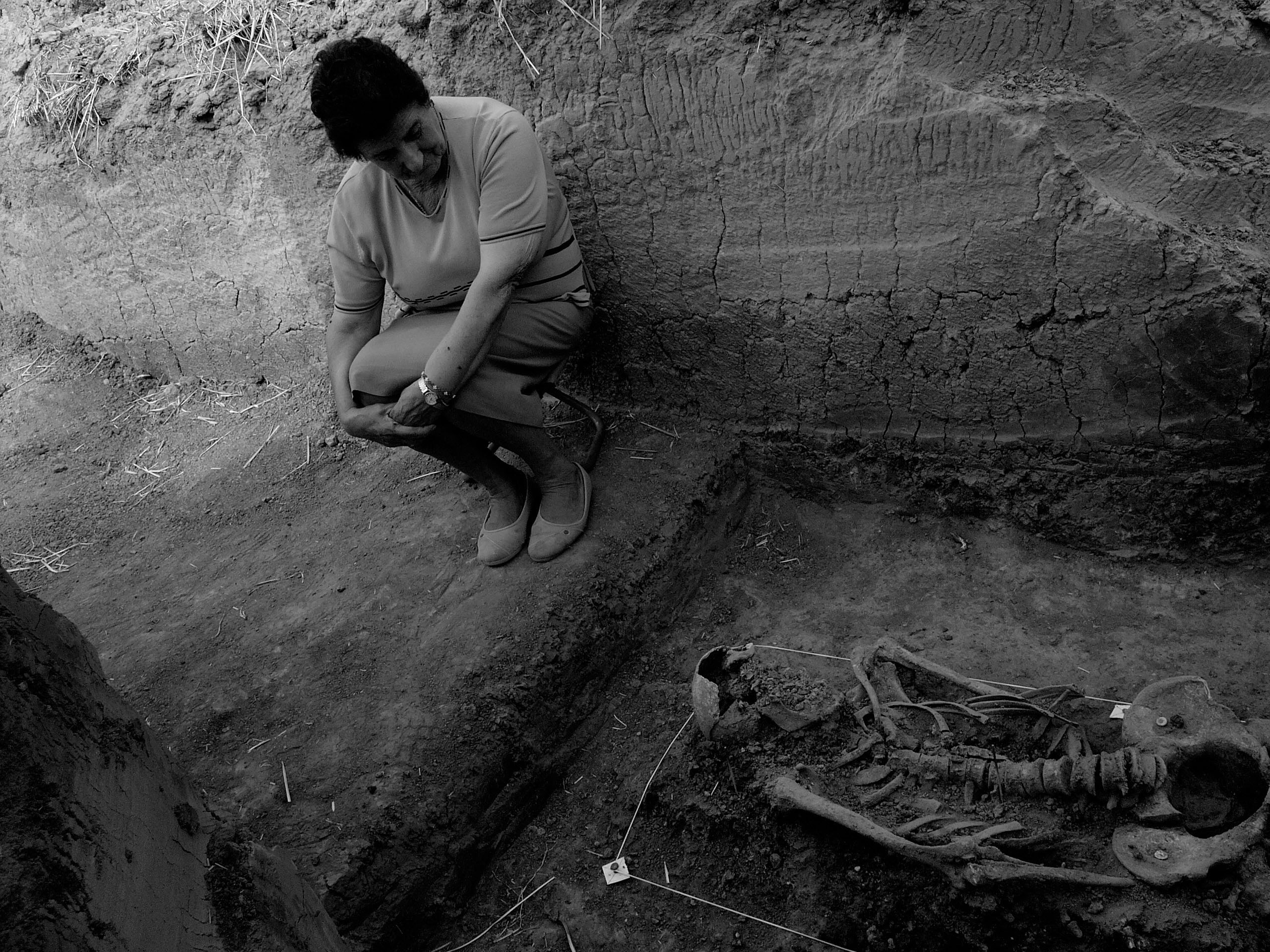 Berlangas de Roa (Burgos), 2004. Exhumation of the remains of five inhabitants of Haza (Burgos) who were detained and assassinated in August 1936, among them the mayor of the town. The mayor’s daughter sits beside her father’s remains. Photo Clemente Bernad. From Desvelados.