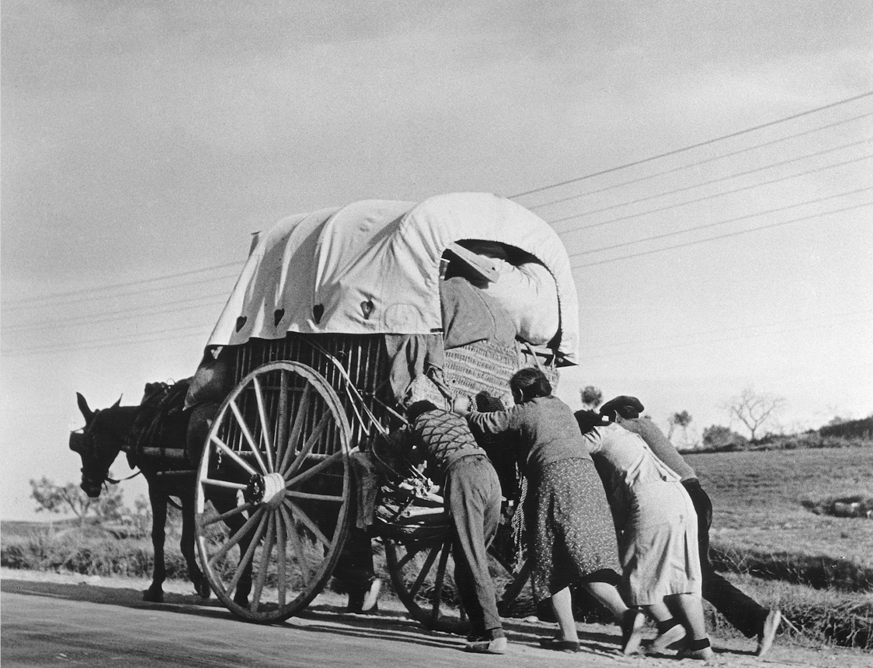 Robert Capa. Civilians from the threatened town of Tarragona pushing their wagon on their way to seek refuge in Barcelona, before that city itself had to be evacuated, January 15, 1939. © International Center of Photography/Magnum Photos.
